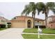 Well-maintained home with a two-car garage, arched entryway, and lush lawn and landscaping at 4535 Gateway Blvd, Wesley Chapel, FL 33544