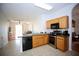 Functional kitchen featuring wood cabinetry, stainless steel appliances, and an open view to the living area at 4535 Gateway Blvd, Wesley Chapel, FL 33544