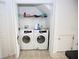 A closet containing a modern white washer and dryer sits on tiled flooring at 4535 Gateway Blvd, Wesley Chapel, FL 33544