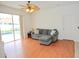 Living room boasts wood flooring, ceiling fan, and sliding glass doors overlooking the pool at 4535 Gateway Blvd, Wesley Chapel, FL 33544
