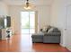 Bright living room featuring hardwood floors, a comfortable sofa, and sliding glass doors leading to the pool at 4535 Gateway Blvd, Wesley Chapel, FL 33544