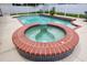 Close up of backyard in-ground pool and hot tub with brick and tile trim at 4535 Gateway Blvd, Wesley Chapel, FL 33544