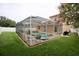 Screened-in pool with patio, hot tub, seating, and a well-manicured yard at 4535 Gateway Blvd, Wesley Chapel, FL 33544