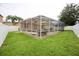 Screened-in pool and hot tub in a well-maintained backyard with green grass at 4535 Gateway Blvd, Wesley Chapel, FL 33544