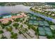 Aerial view showcasing the community's pool, tennis courts, clubhouse, and surrounding water feature at 4830 Grand Banks Dr, Wimauma, FL 33598