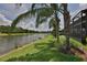 Scenic view of the lake from the backyard, with palm trees and the home's screened-in porch visible at 4830 Grand Banks Dr, Wimauma, FL 33598