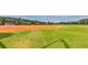 Baseball field featuring well-maintained green grass, clay infield, and covered dugouts at 4830 Grand Banks Dr, Wimauma, FL 33598