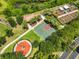 Aerial view of a red and green basketball court with community garden and monument at 4830 Grand Banks Dr, Wimauma, FL 33598