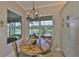 Bright breakfast nook features a round table with a water view and an elegant chandelier at 4830 Grand Banks Dr, Wimauma, FL 33598