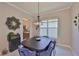 Stylish dining room with an elegant chandelier, comfortable blue velvet chairs, and nearby kitchen at 4830 Grand Banks Dr, Wimauma, FL 33598