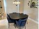 Cozy dining room with elegant chandelier and comfortable blue velvet chairs at 4830 Grand Banks Dr, Wimauma, FL 33598