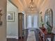 Elegant foyer with hardwood floors, tray ceiling, and decorative lighting fixture at 4830 Grand Banks Dr, Wimauma, FL 33598