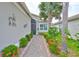 Inviting walkway to front door with lush tropical landscaping and custom metal heron art at 4830 Grand Banks Dr, Wimauma, FL 33598