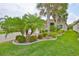 Landscaped yard with tropical plants and lush green grass at 4830 Grand Banks Dr, Wimauma, FL 33598