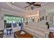 Large living room with hardwood floors, a ceiling fan, and a panoramic view of the backyard and lake at 4830 Grand Banks Dr, Wimauma, FL 33598