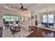 Spacious living room with a ceiling fan, hardwood floors, a dining table, and a view of the lake at 4830 Grand Banks Dr, Wimauma, FL 33598
