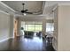 Bright living room with hardwood floors, ceiling fan, and sliding doors to the lanai with lake view at 4830 Grand Banks Dr, Wimauma, FL 33598