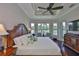 Bright main bedroom featuring tray ceiling, fan, views to the water and hardwood floors at 4830 Grand Banks Dr, Wimauma, FL 33598
