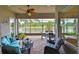 Relaxing screened-in patio with comfortable seating and peaceful water views of the lake at 4830 Grand Banks Dr, Wimauma, FL 33598