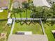 Aerial view of a home and backyard, featuring lush green grass, palm trees, and a privacy fence at 4852 Trinidad Dr, Land O Lakes, FL 34639