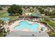 Aerial view of a community pool, playground and picnic area surrounded by lush greenery and sidewalks at 4852 Trinidad Dr, Land O Lakes, FL 34639