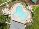 A bird's eye view shows a community pool and hot tub surrounded by lush landscaping and lounge chairs at 4852 Trinidad Dr, Land O Lakes, FL 34639