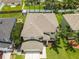 An aerial view shows a well maintained home with a lawn and palm trees in a Florida neighborhood at 4852 Trinidad Dr, Land O Lakes, FL 34639