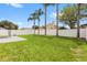 Spacious backyard with lush grass, palm trees, white fence, and a concrete patio for outdoor living at 4852 Trinidad Dr, Land O Lakes, FL 34639