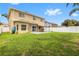 Large backyard with green lawn, patio, privacy fence, and plenty of space for outdoor activities at 4852 Trinidad Dr, Land O Lakes, FL 34639