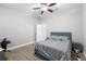 A charming bedroom with gray wood-look floors, ceiling fan, bed, and closet, with natural light at 4852 Trinidad Dr, Land O Lakes, FL 34639