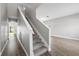 Hallway view with carpeted stairs leading to the upper level and wood floors on the lower level at 4852 Trinidad Dr, Land O Lakes, FL 34639