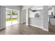 Bright living room featuring wood floors, open to the kitchen, and a sliding door to the backyard at 4852 Trinidad Dr, Land O Lakes, FL 34639