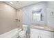 Updated bathroom featuring granite countertop, white vanity, tiled shower and bathtub at 5012 Troydale Rd, Tampa, FL 33615