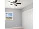 Cozy bedroom with a ceiling fan, window views, and closet doors at 5012 Troydale Rd, Tampa, FL 33615
