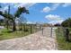 Paver driveway leads to a charming home with a secure gate and well-maintained landscaping at 5012 Troydale Rd, Tampa, FL 33615