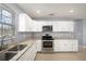 Updated kitchen with stainless steel appliances, stone countertops, and white cabinets at 5012 Troydale Rd, Tampa, FL 33615