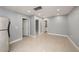Open living room with tile floors, neutral gray walls, and multiple doorways at 5012 Troydale Rd, Tampa, FL 33615