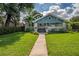 Charming home featuring a landscaped front yard, inviting porch, and classic architectural details at 5301 N Central Ave, Tampa, FL 33603