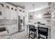 Stylish kitchen showcasing white cabinets, stainless appliances, pendant lighting, and unique tile floors at 5301 N Central Ave, Tampa, FL 33603