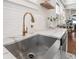 Close-up of the kitchen sink with a stainless-steel basin, marble countertops, and gold faucet at 5301 N Central Ave, Tampa, FL 33603