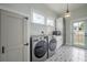 Bright laundry room with a washer and dryer, storage cabinets, tiled flooring, and natural light at 5301 N Central Ave, Tampa, FL 33603