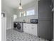 Well-lit laundry room with modern appliances, gray cabinets, and decorative tiled flooring at 5301 N Central Ave, Tampa, FL 33603