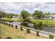Backyard view of canal with a white fence and well maintained lawn at 6334 Spring Flower Dr # 24, New Port Richey, FL 34653
