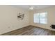 Bright bedroom featuring wood floors, a ceiling fan, and a large window, complemented by neutral paint at 6334 Spring Flower Dr # 24, New Port Richey, FL 34653