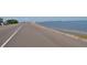 Coastal road curving along a bay with parked cars and an island in the distance at 6334 Spring Flower Dr # 24, New Port Richey, FL 34653