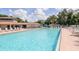 Large community pool with a bright blue, inviting design with comfortable lounge chairs and a nearby clubhouse at 6334 Spring Flower Dr # 24, New Port Richey, FL 34653