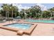Relaxing community hot tub adjacent to a large pool, surrounded by comfortable seating and lush landscaping at 6334 Spring Flower Dr # 24, New Port Richey, FL 34653