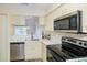 Kitchen featuring stainless steel appliances, white cabinetry, and quartz countertops at 6334 Spring Flower Dr # 24, New Port Richey, FL 34653
