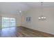 Bright living room with wood floors, modern ceiling fan, and sliding glass door leading to an outdoor space at 6334 Spring Flower Dr # 24, New Port Richey, FL 34653