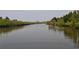 Scenic view of the waterway with lush mangroves and a small pier, providing a serene natural backdrop at 6334 Spring Flower Dr # 24, New Port Richey, FL 34653